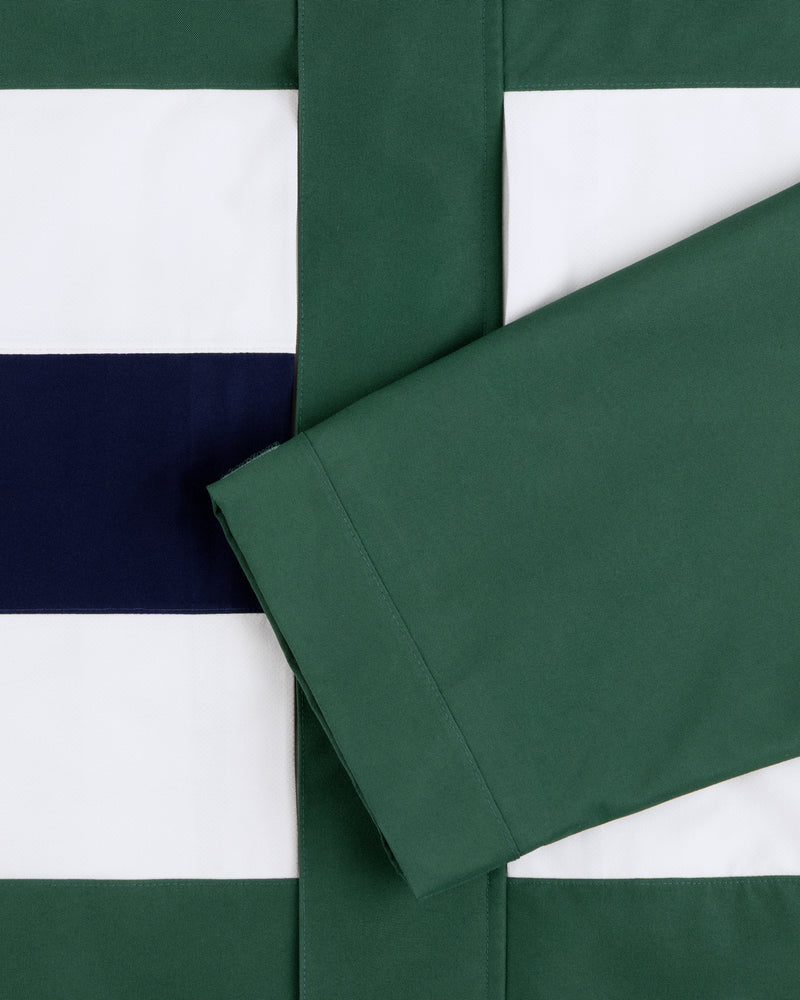 A green sleeve rests on striped white, navy, and green GORE-TEX Striped Sailing Jacket fabric.