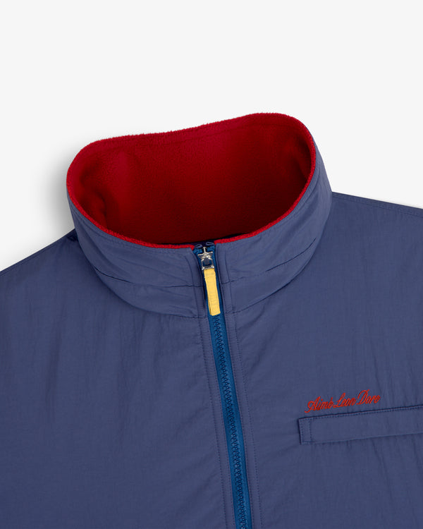 Fleece Lined Sport Windbreaker: blue zip-up with high red fleece collar, yellow zipper pull, and red chest embroidery.