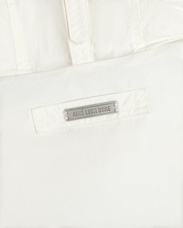 White Down-Filled Surplus Parka with a metallic brand name tag on the front pocket.