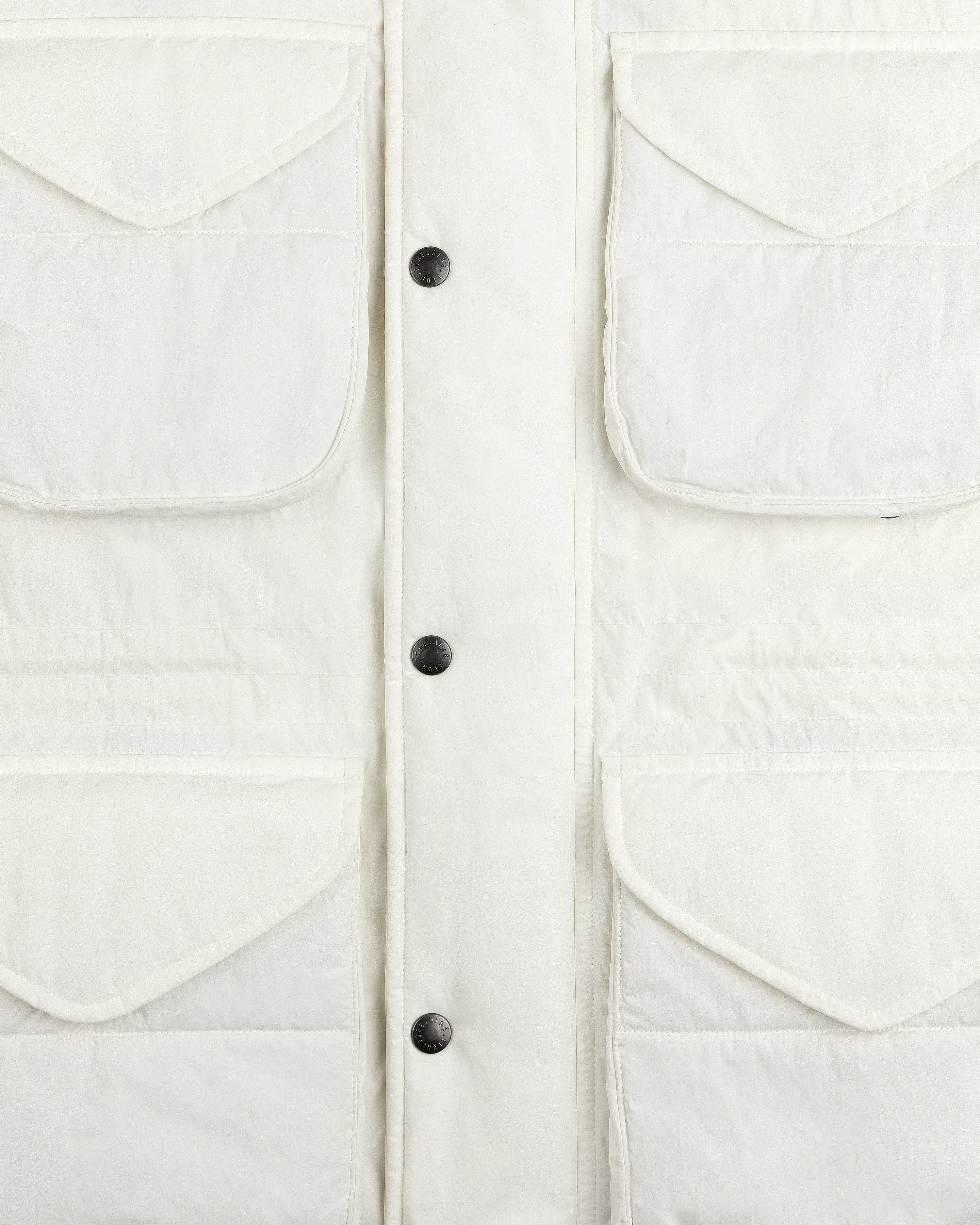 Close-up of a white Down-Filled Surplus Parka with four front flap pockets and a button-down placket.