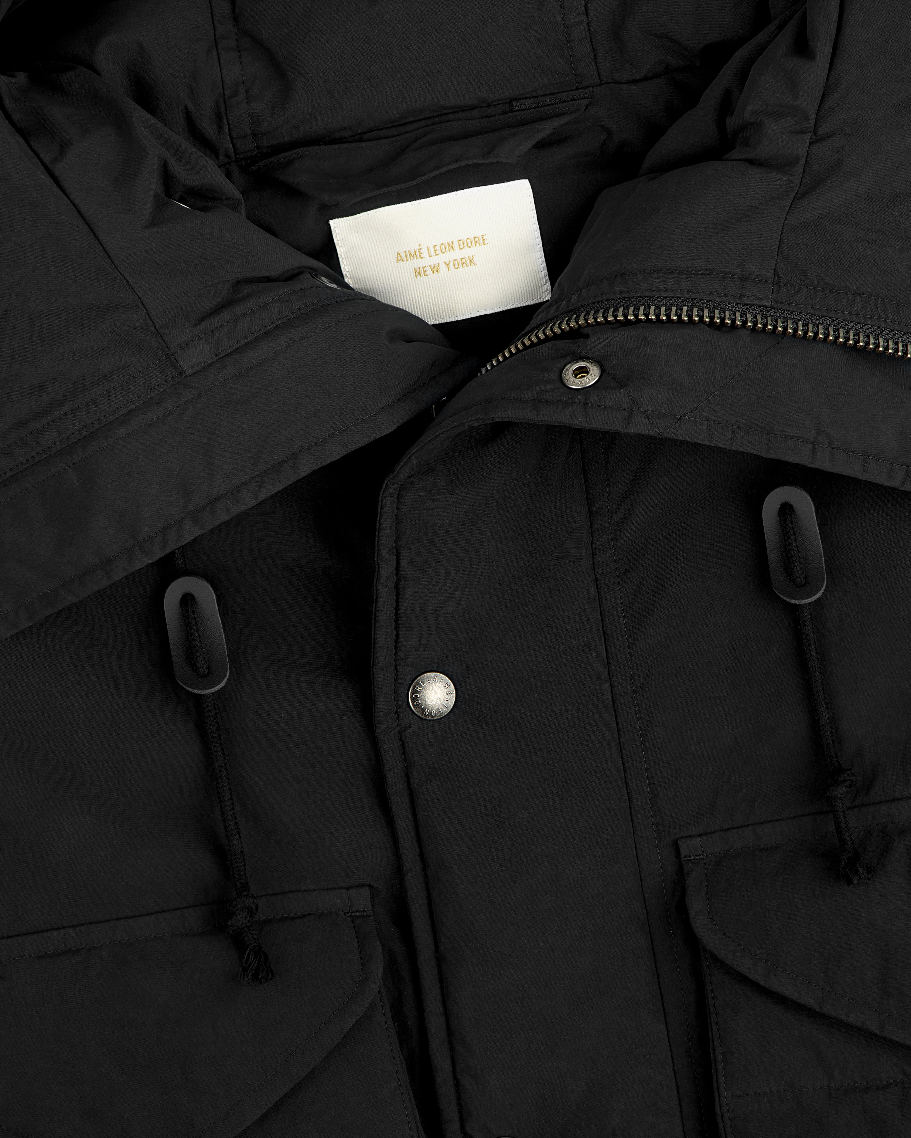 Close-up of a black Down-Filled Surplus Parka with metal snap buttons and drawstrings.