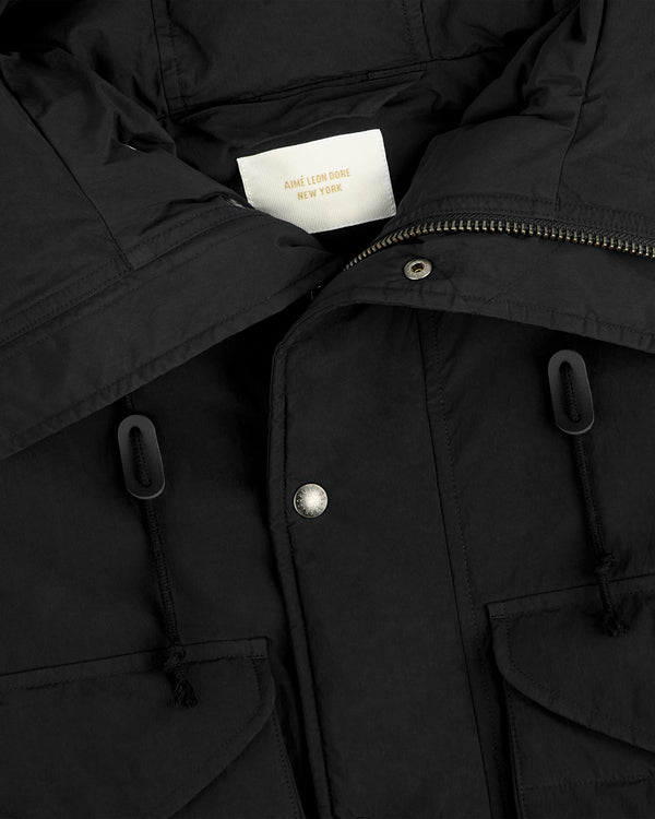 Close-up of a black Down-Filled Surplus Parka with metal snap buttons and drawstrings.