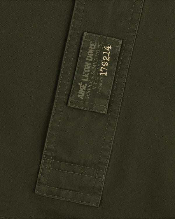 Olive green Garment Washed Anorak fabric with a rectangular patch featuring branded text and the number 179214.