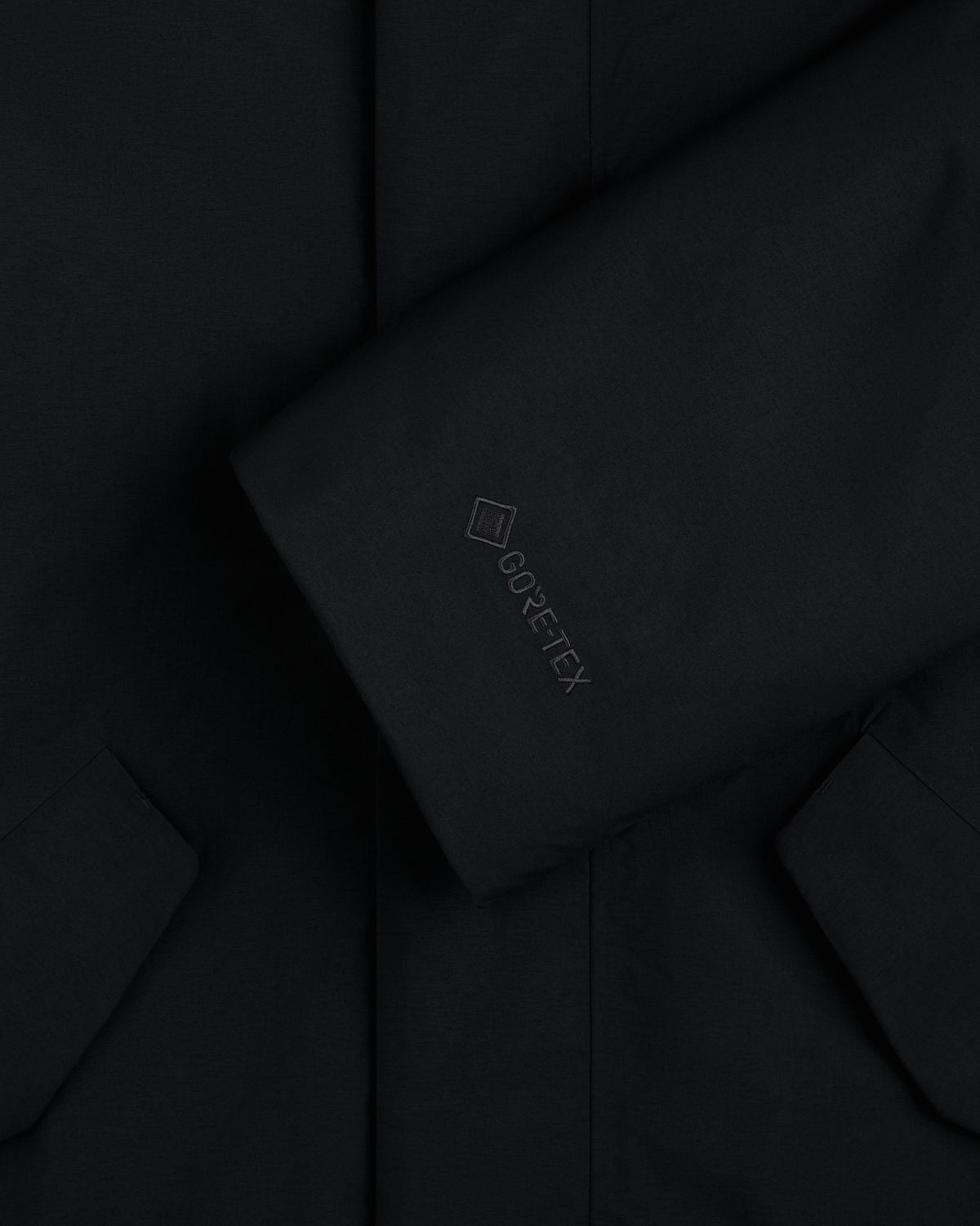 Close-up of a black GORE-TEX Down Filled Fishtail Parka sleeve with a tonal GORE-TEX logo.