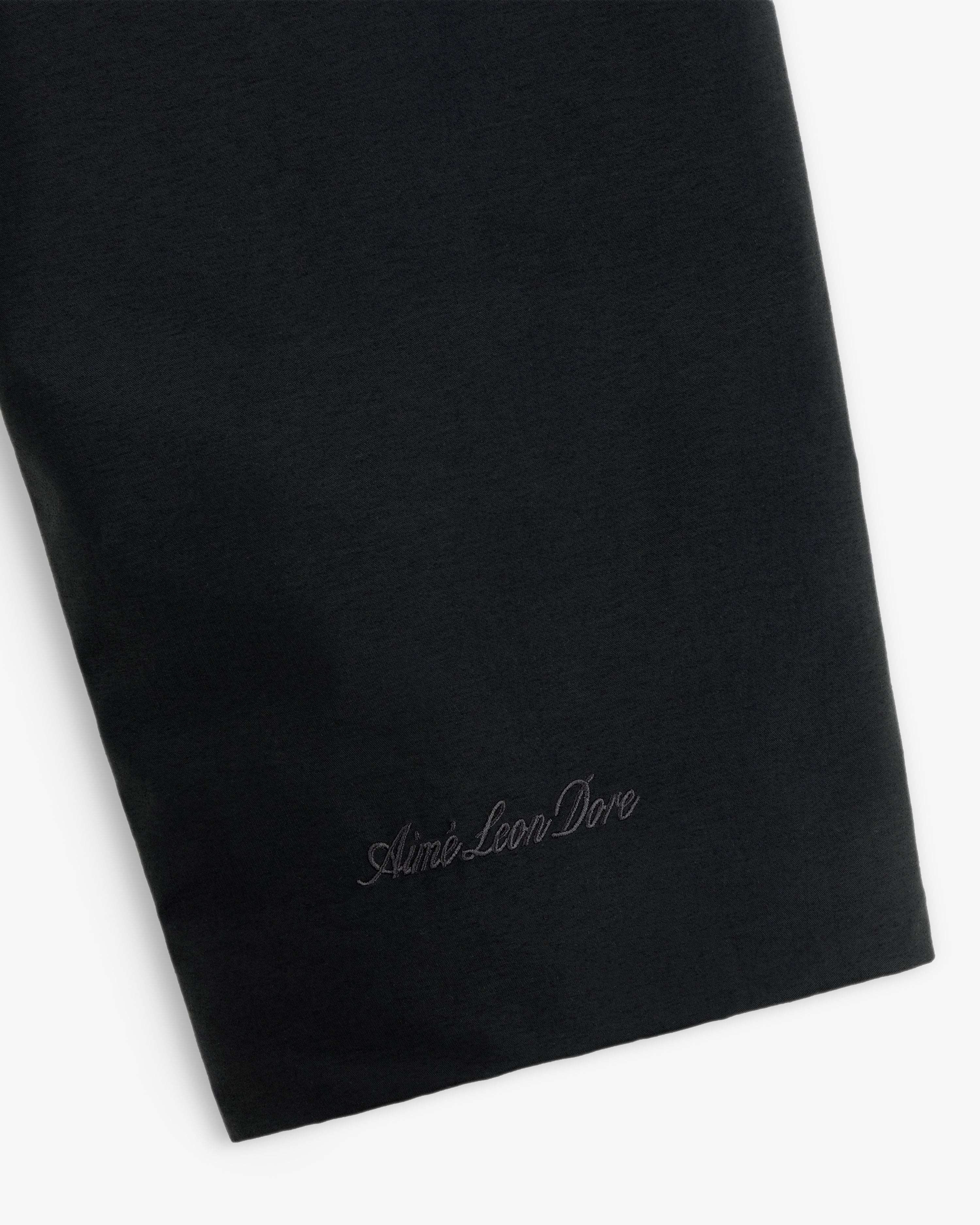 Close-up of a black GORE-TEX Down Filled Fishtail Parka sleeve featuring tonal brand embroidery at the cuff.