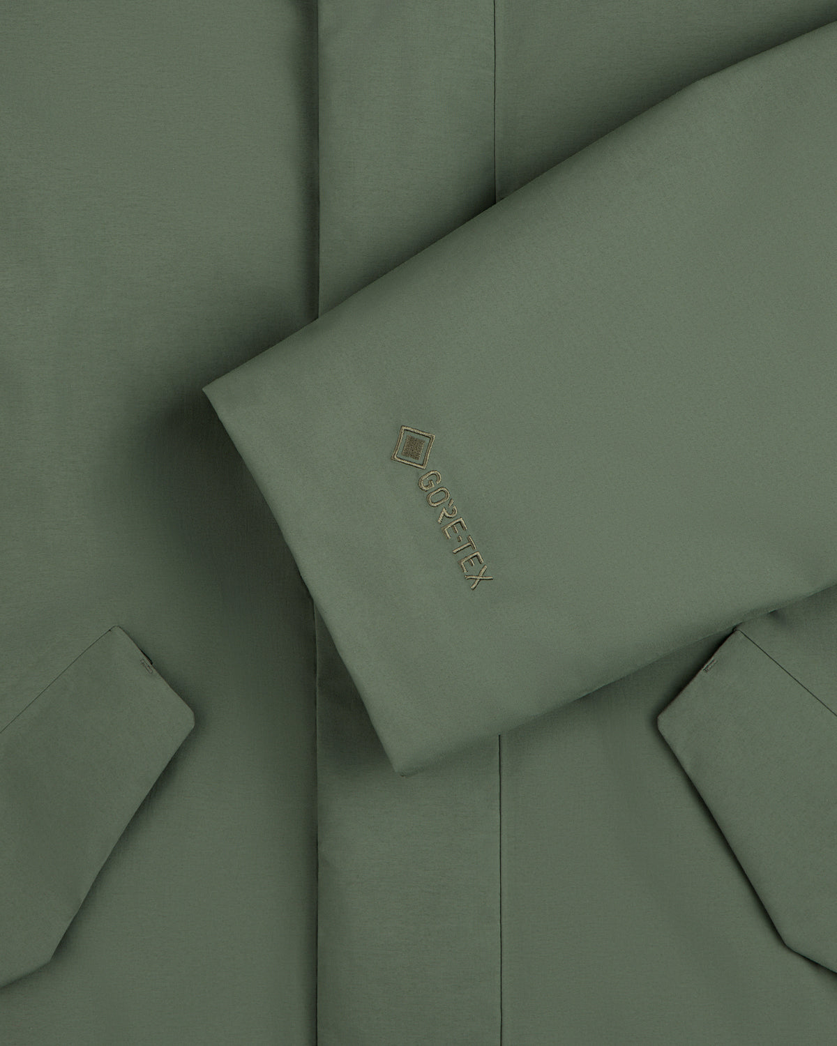 Olive green sleeve of the GORE-TEX Down Filled Fishtail Parka with a Gore-Tex logo on the cuff.