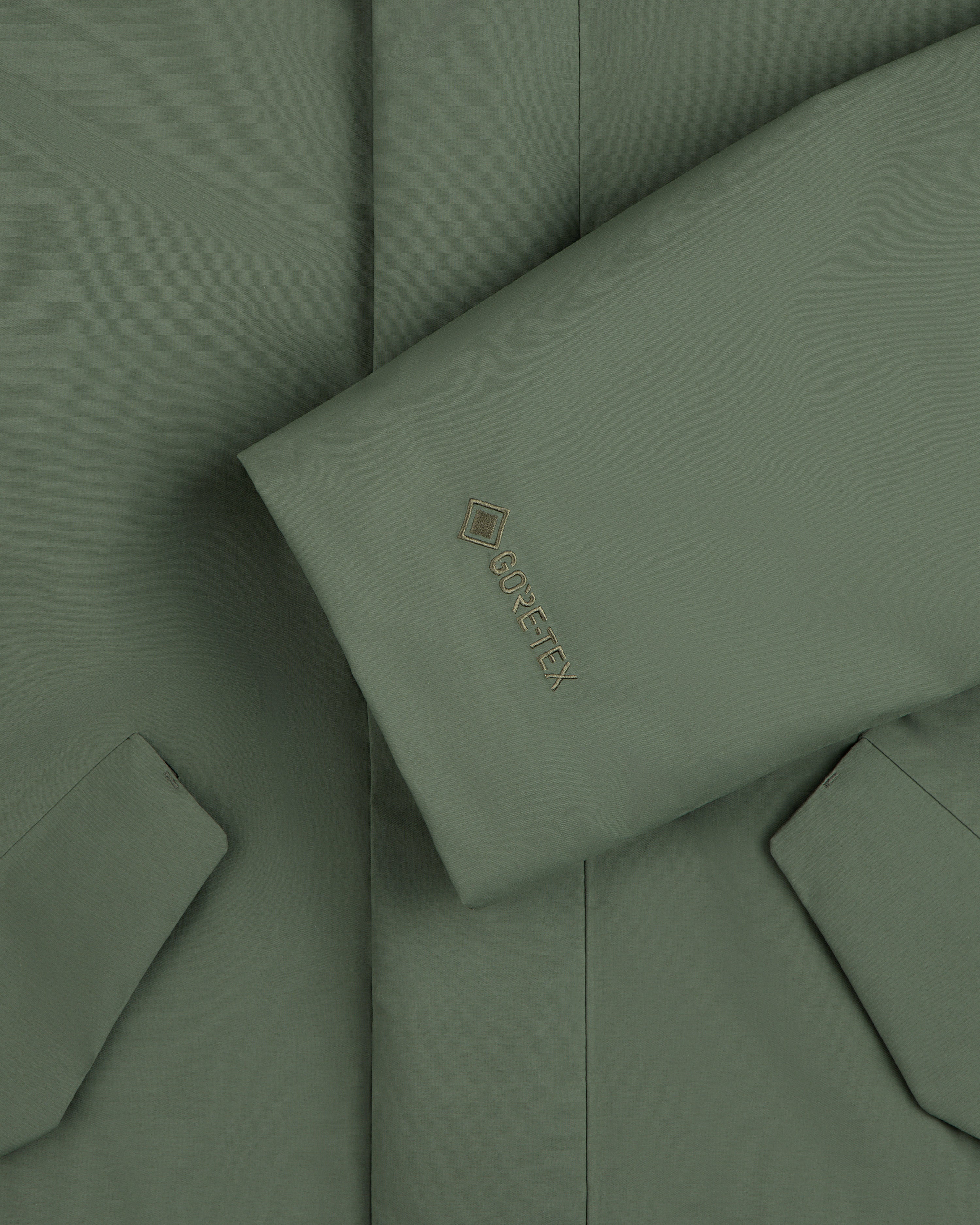 Olive green sleeve of the GORE-TEX Down Filled Fishtail Parka with a Gore-Tex logo on the cuff.