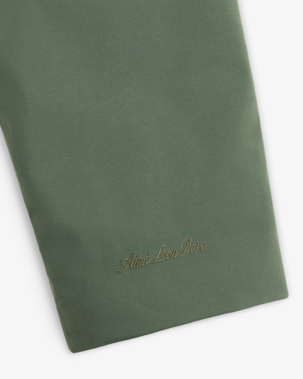 Olive green sleeve of the GORE-TEX Down Filled Fishtail Parka with an embroidered logo in script font near the cuff.