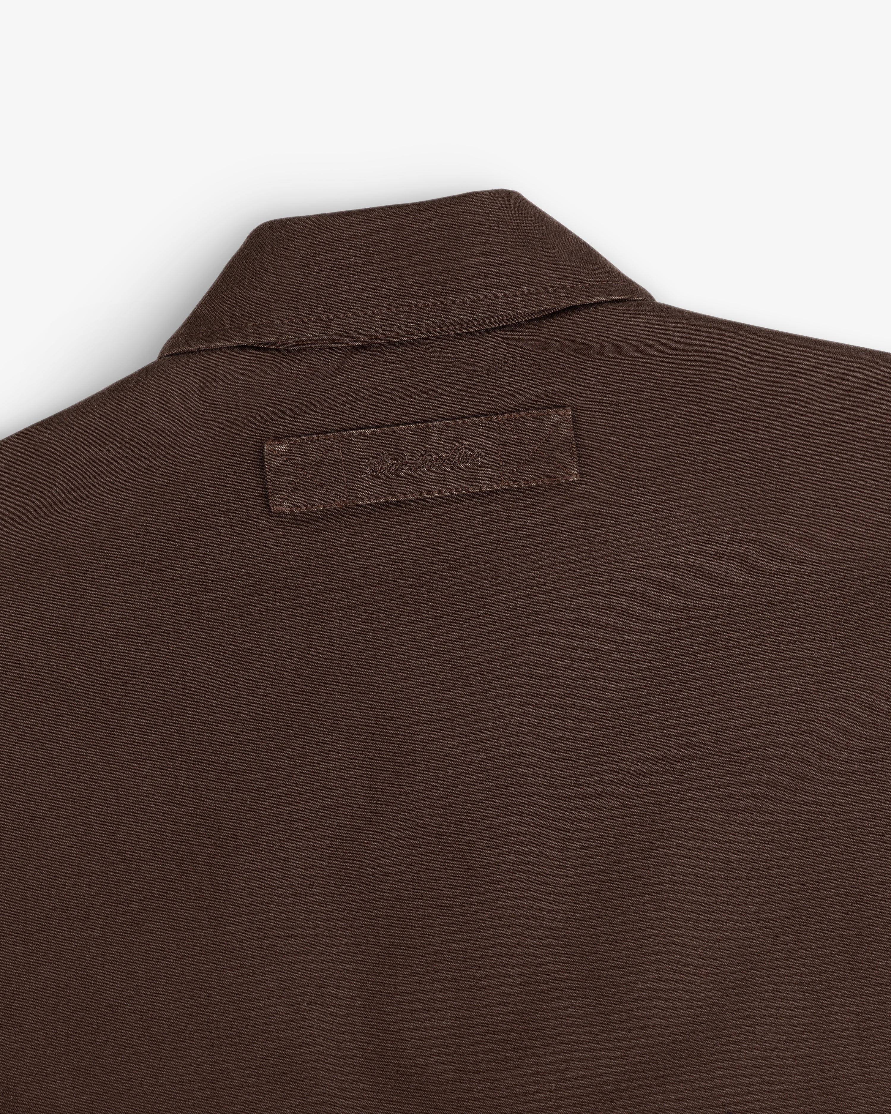 Close-up of the back collar of a dark brown Fleece Lined Mechanic Jacket featuring a rectangular fabric patch.
