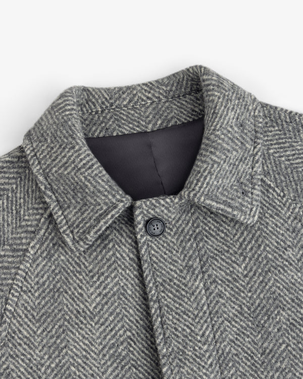 Wool Herringbone Overcoat in grey with a herringbone pattern, a collar, and a single button at the neck.