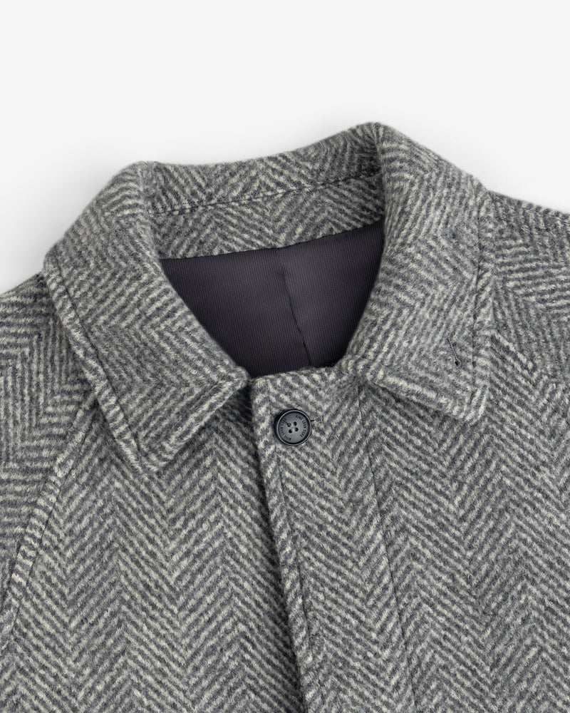 Wool Herringbone Overcoat in grey with a herringbone pattern, a collar, and a single button at the neck.