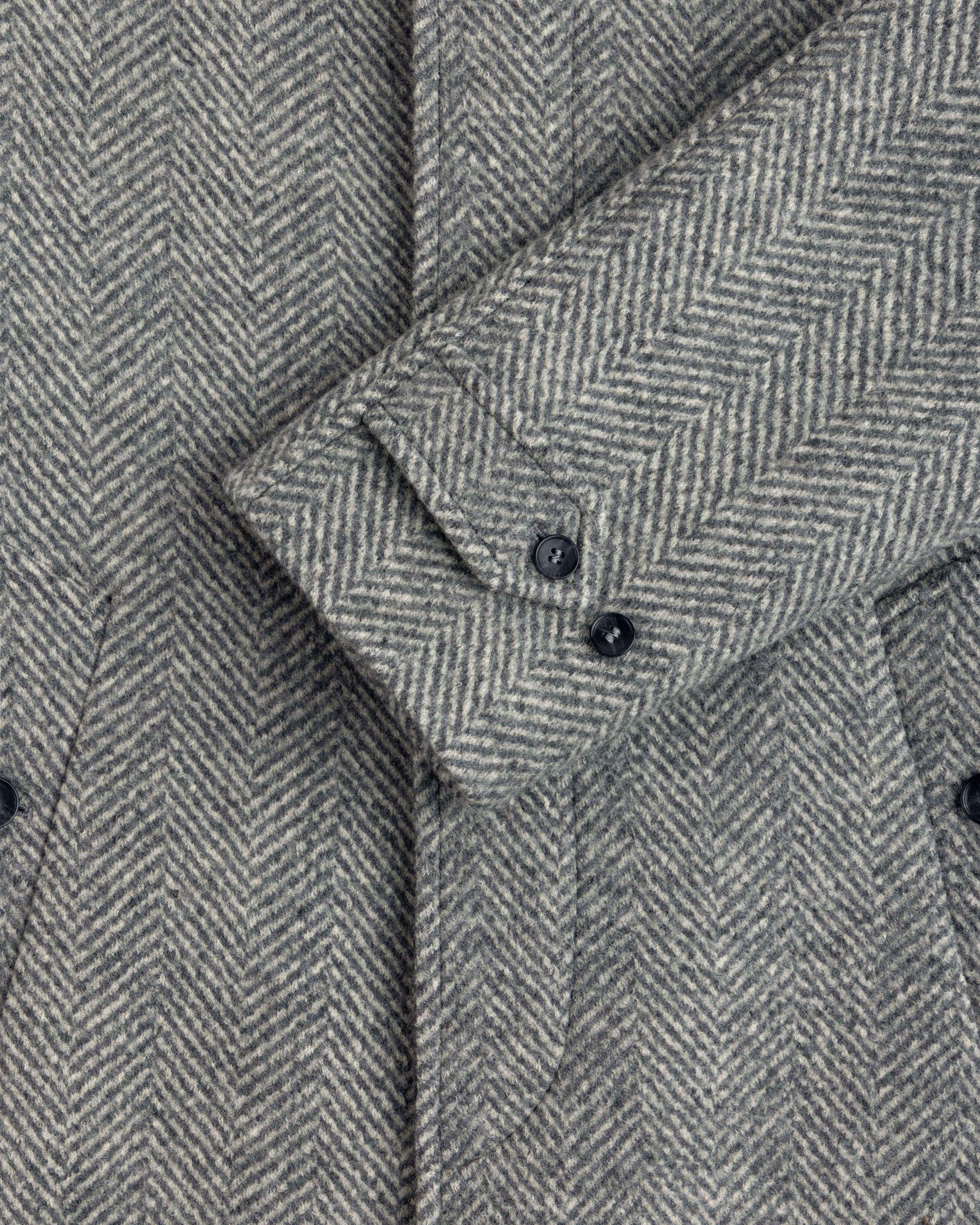 Grey Wool Herringbone Overcoat sleeve featuring two buttons on the cuff.