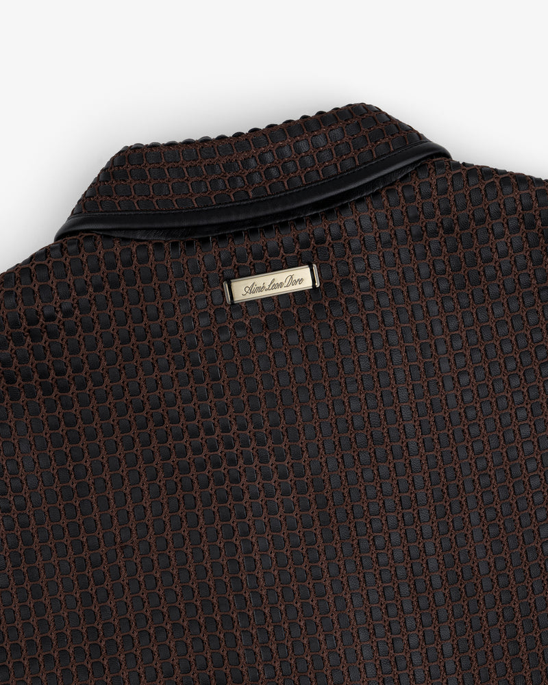 Close-up of a brown and black Woven Leather Jacket collar with a metal brand tag at the neckline.
