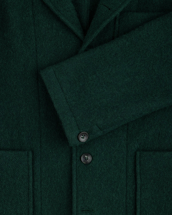 Close-up of a dark green Wool Sport Coat featuring a notched lapel, a buttoned sleeve cuff, and two patch pockets.
