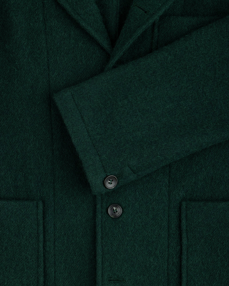 Close-up of a dark green Wool Sport Coat featuring a notched lapel, a buttoned sleeve cuff, and two patch pockets.