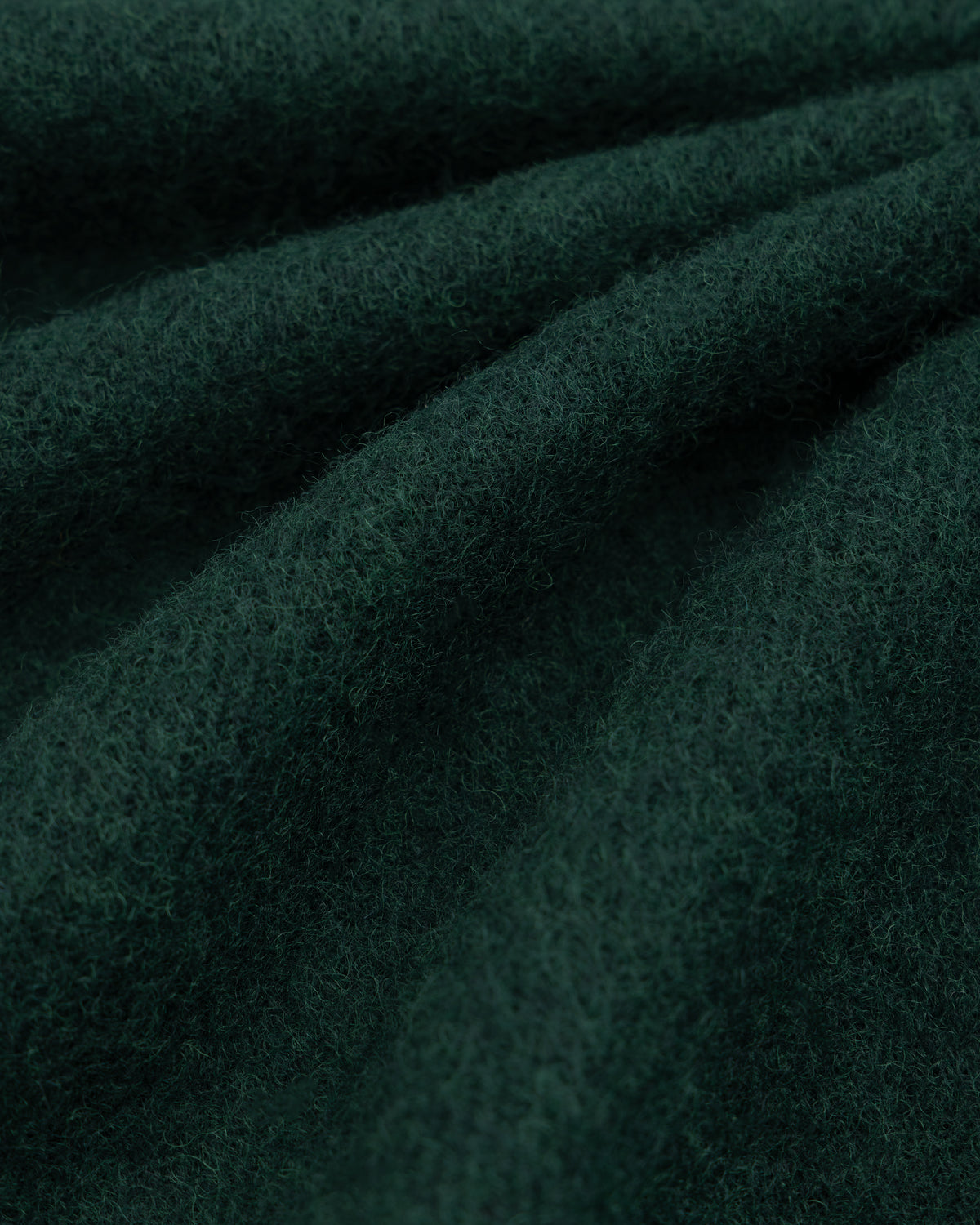 Dark green felted wool fabric of a Wool Sport Coat with soft folds.