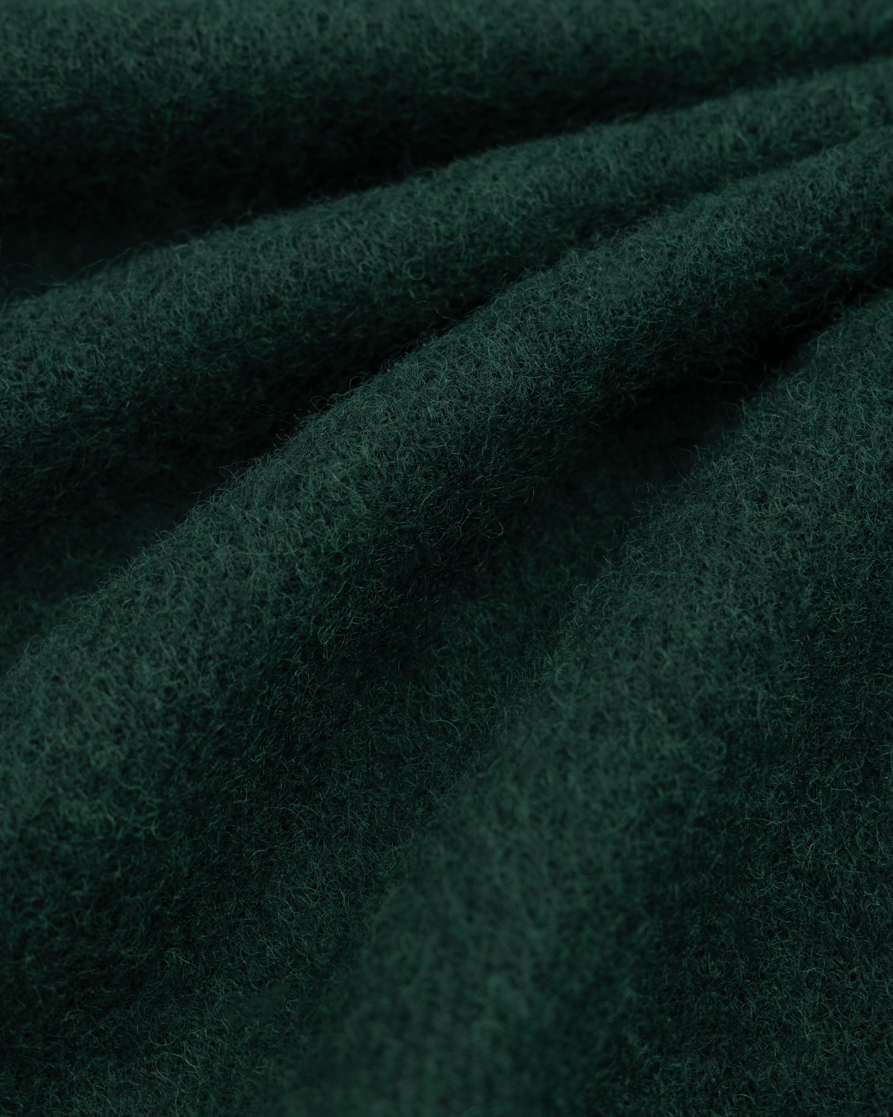 Dark green felted wool fabric of a Wool Sport Coat with soft folds.