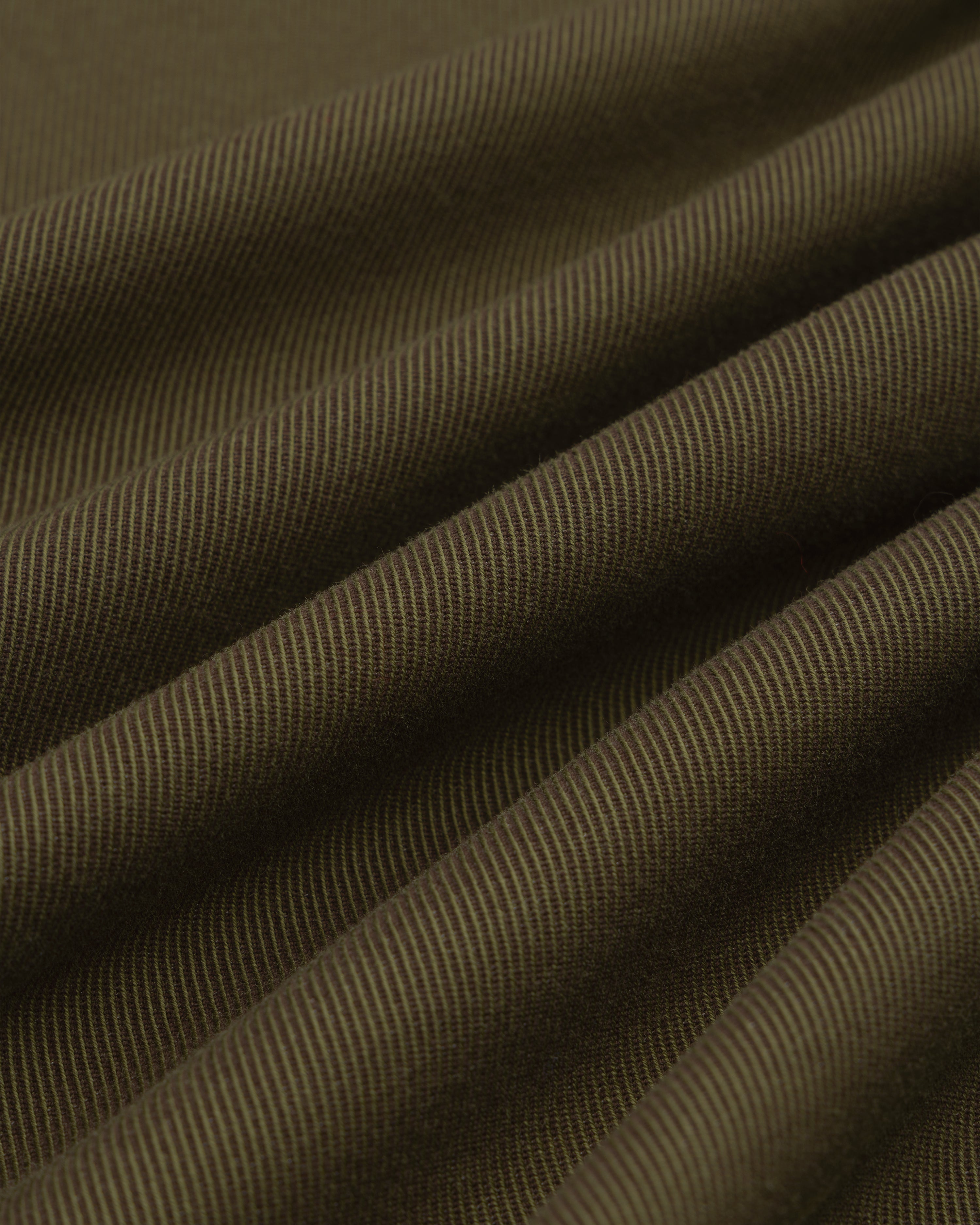Close-up of olive green Single-Breasted Wool Blend Suit Jacket fabric with diagonal ridges in soft, flowing drapes.