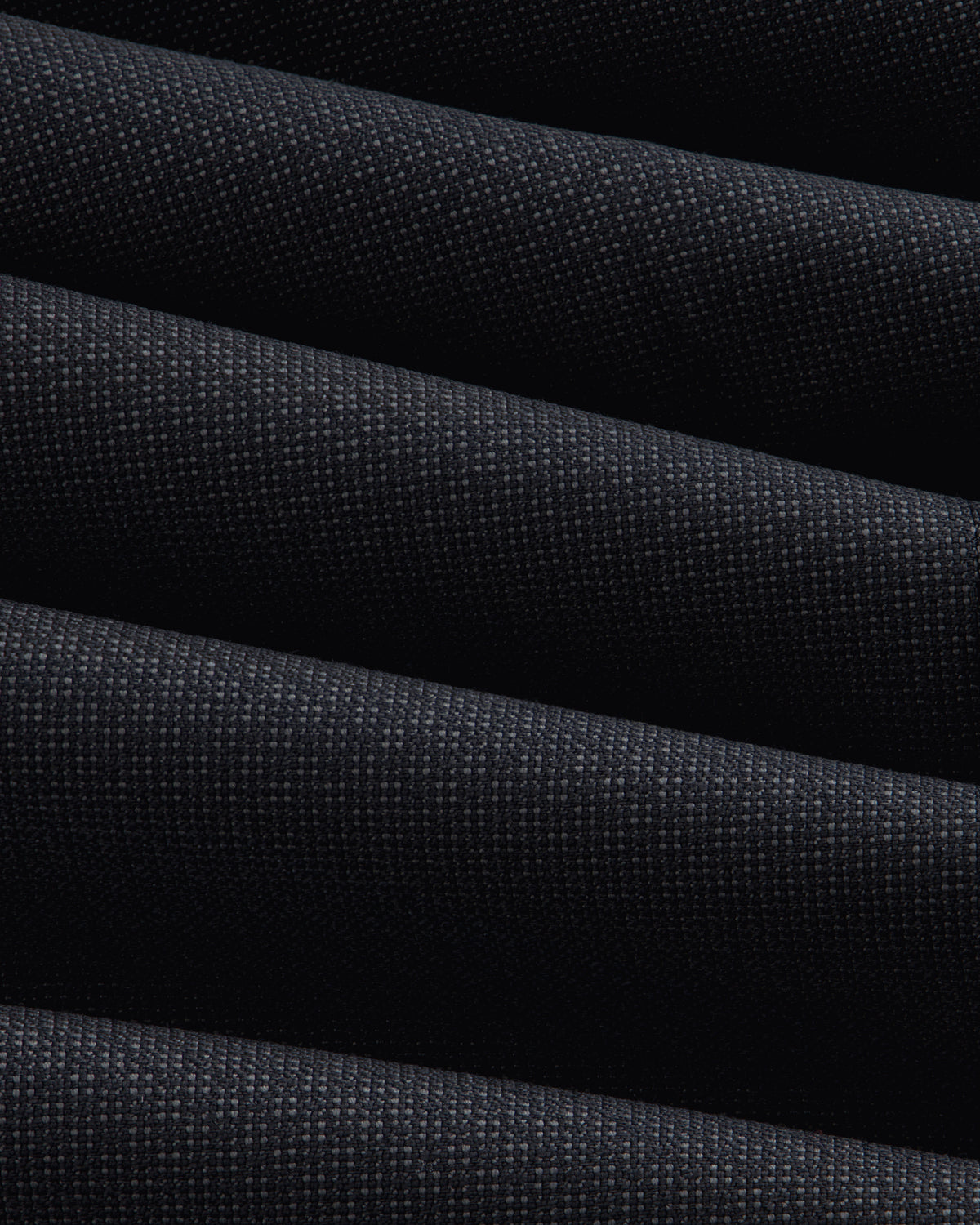 Close-up of the dark, textured fabric of a Double-Breasted Wool Jacquard Suit Jacket with prominent diagonal folds.