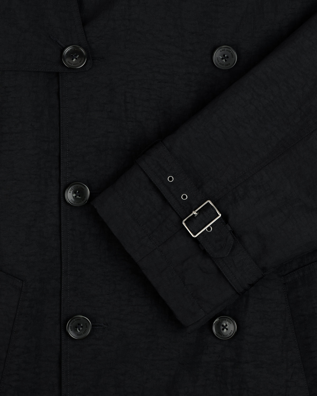 Close-up of the Double Breasted Nylon Trench Coat, featuring black buttons and a sleeve with a small silver buckle.