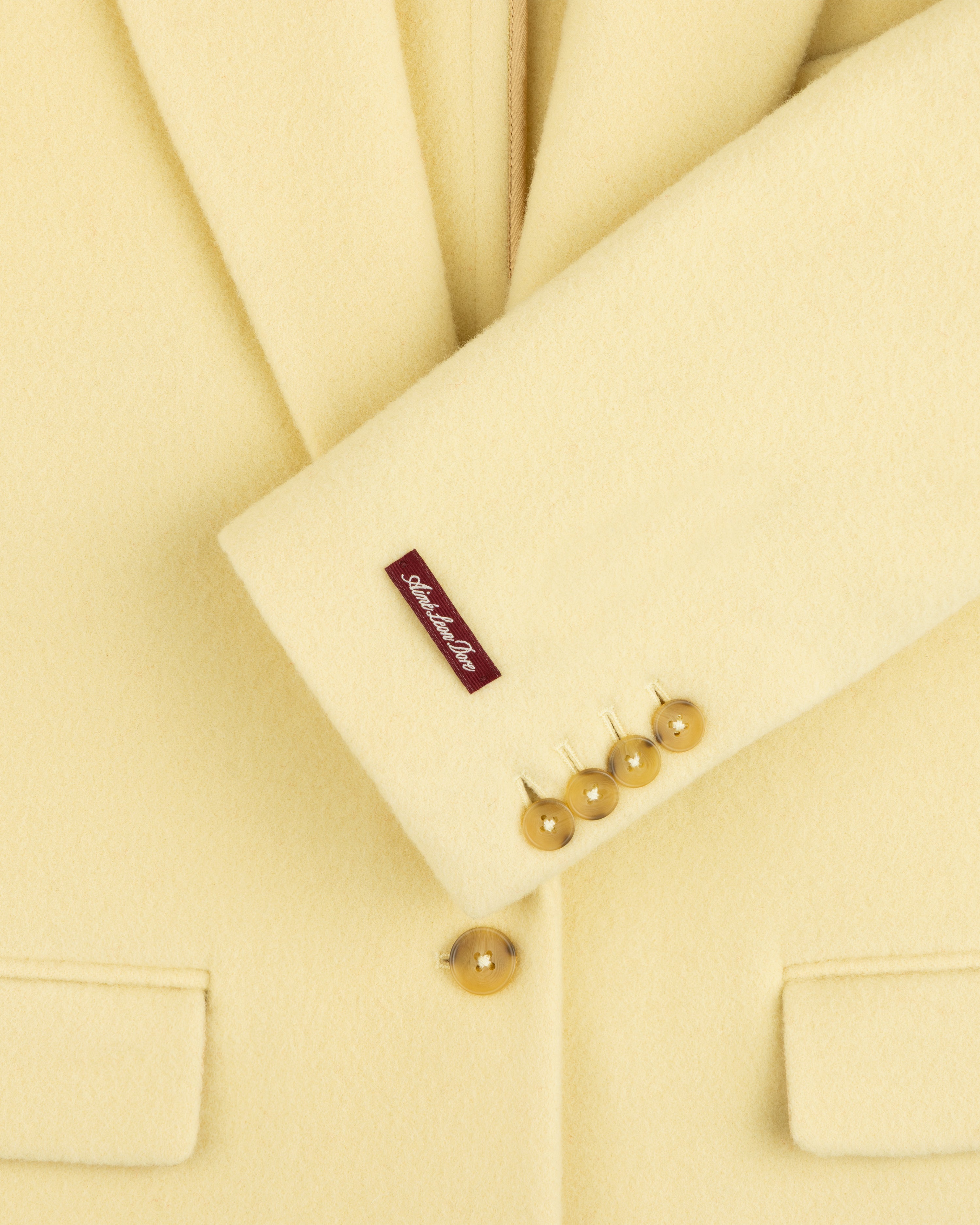 Pale yellow Wool Sportcoat with four cuff buttons and a small label on the sleeve.