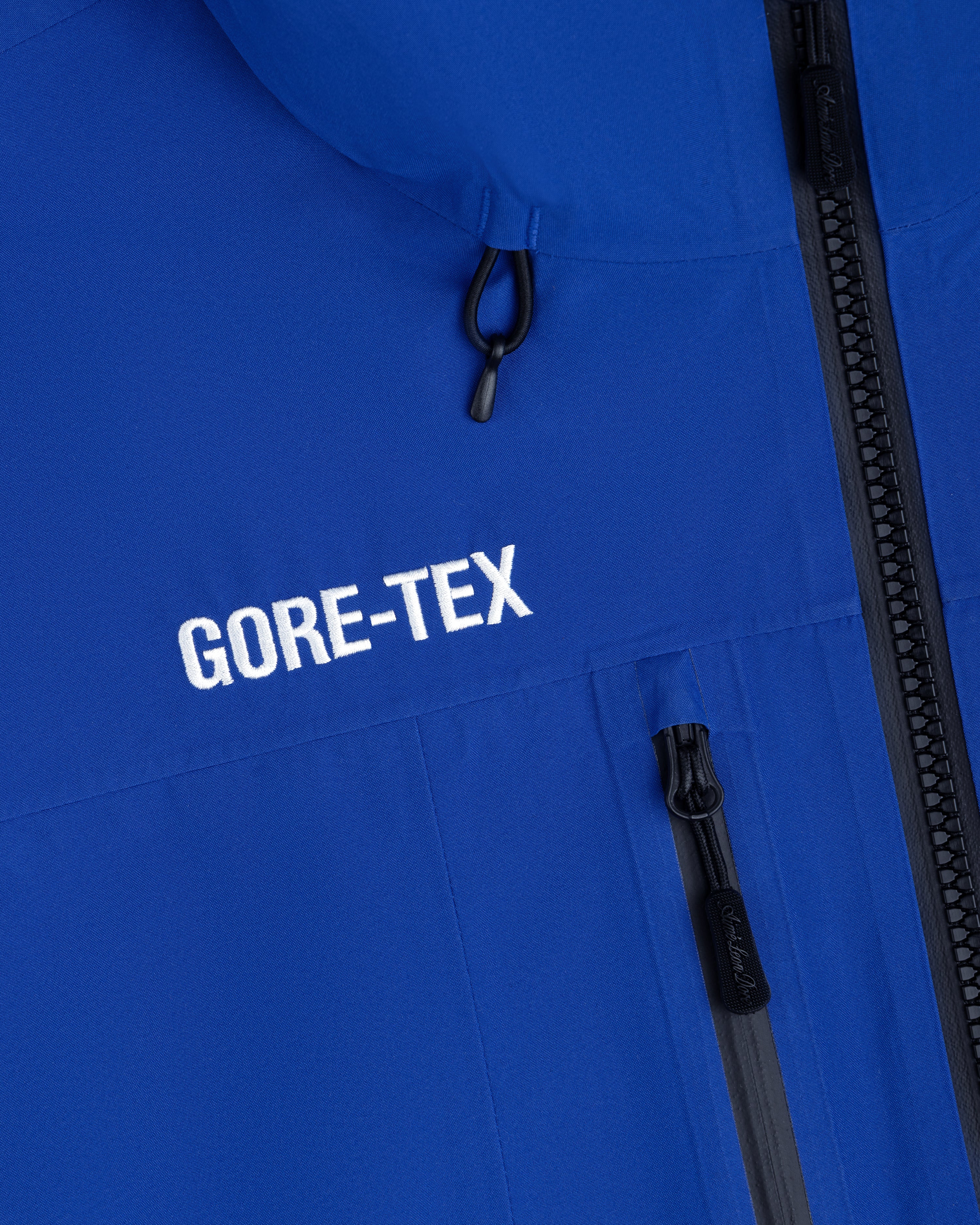 Cropped GORE-TEX Shell Jacket in blue with a black zipper and embroidered logo on the chest.