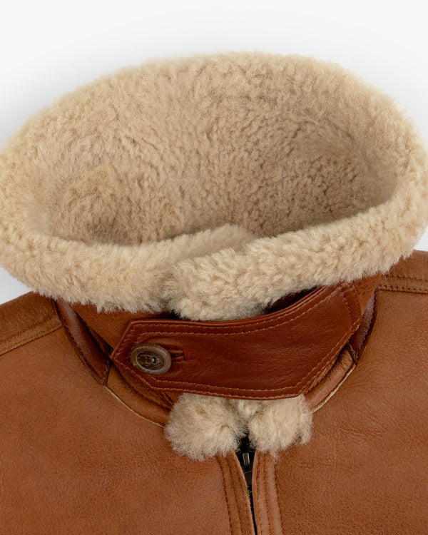 Shearling Bomber Jacket in brown leather with a large tan shearling collar and a buttoned throat latch.