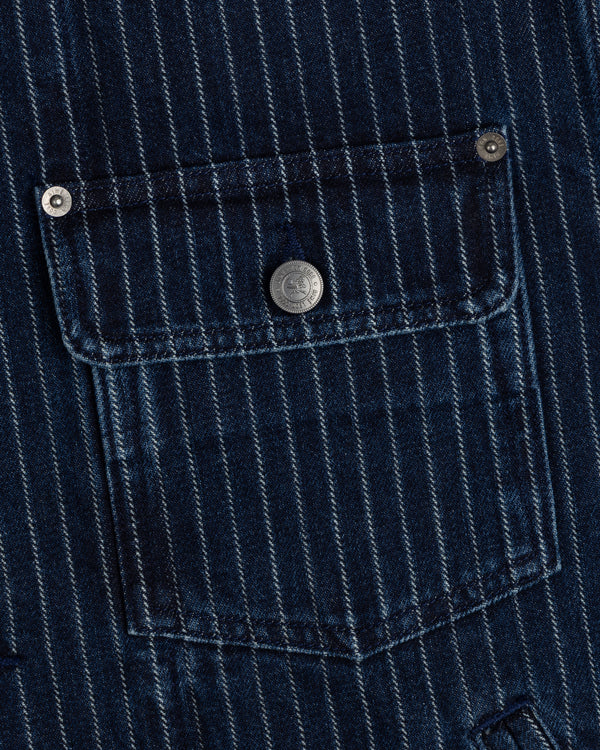 Close-up of Chalk Stripe Denim Trucker Jacket’s blue pinstriped pocket with silver buttons on the flap and corners.