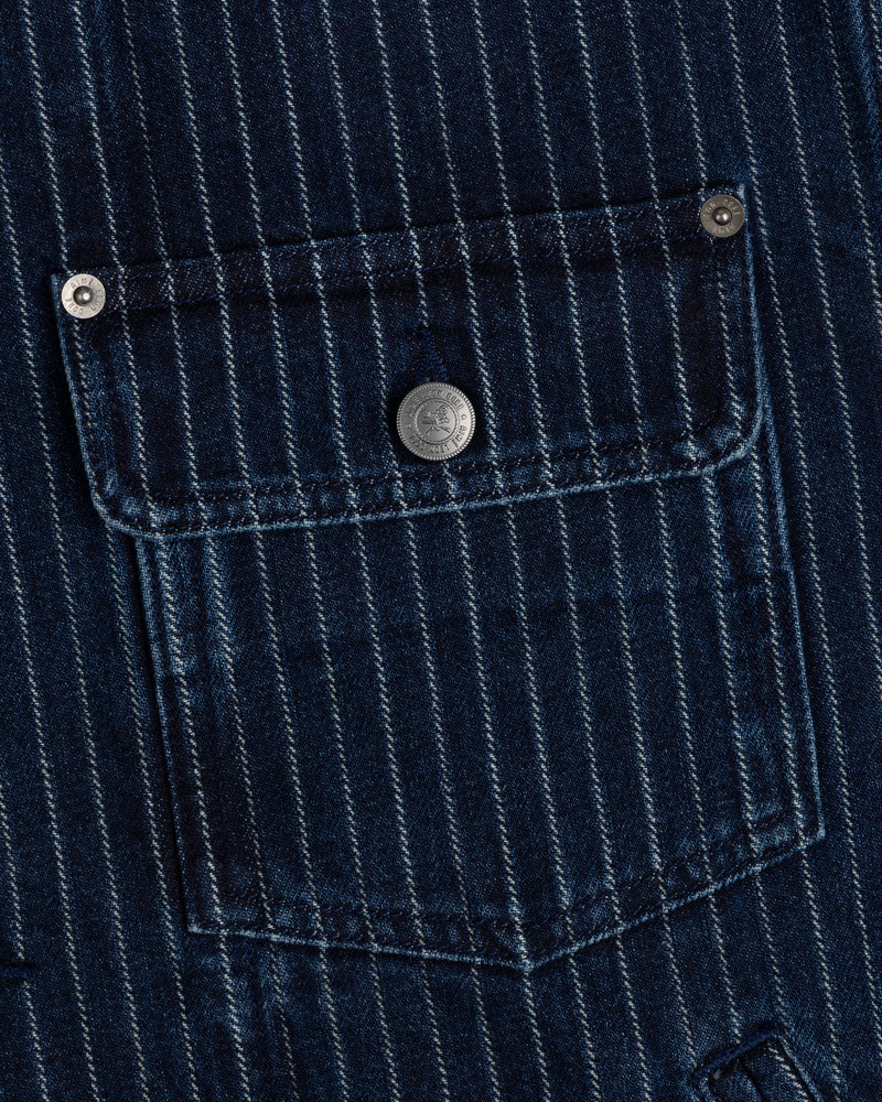 Close-up of Chalk Stripe Denim Trucker Jacket’s blue pinstriped pocket with silver buttons on the flap and corners.