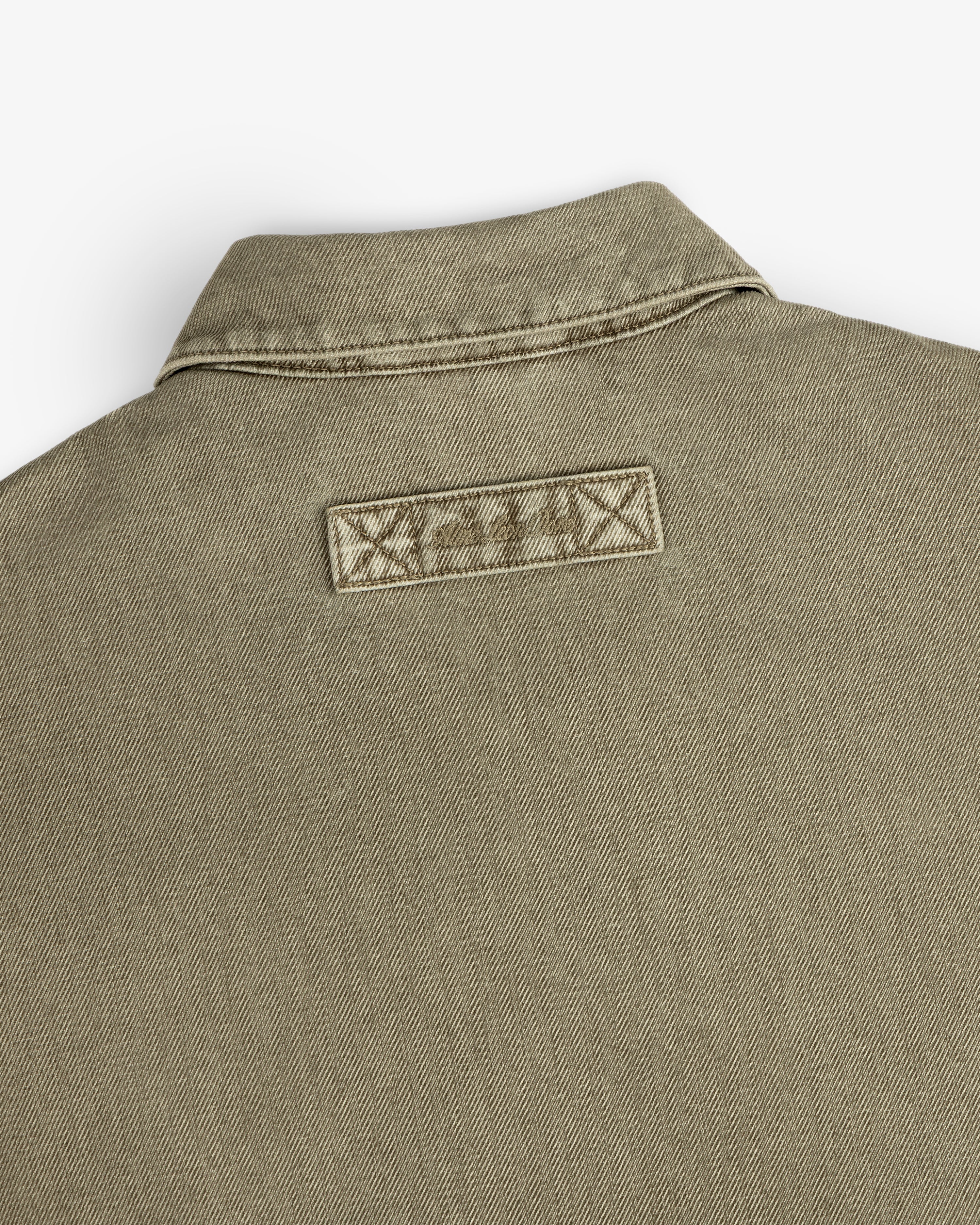 Olive green Flocked Denim Jacket collar with a rectangular patch stitched below the neckline.