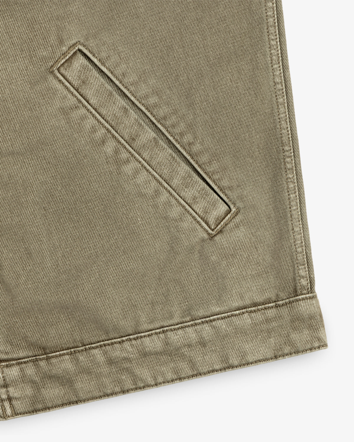 Close-up of a brown Flocked Denim Jacket featuring a single welt pocket and a reinforced hem.