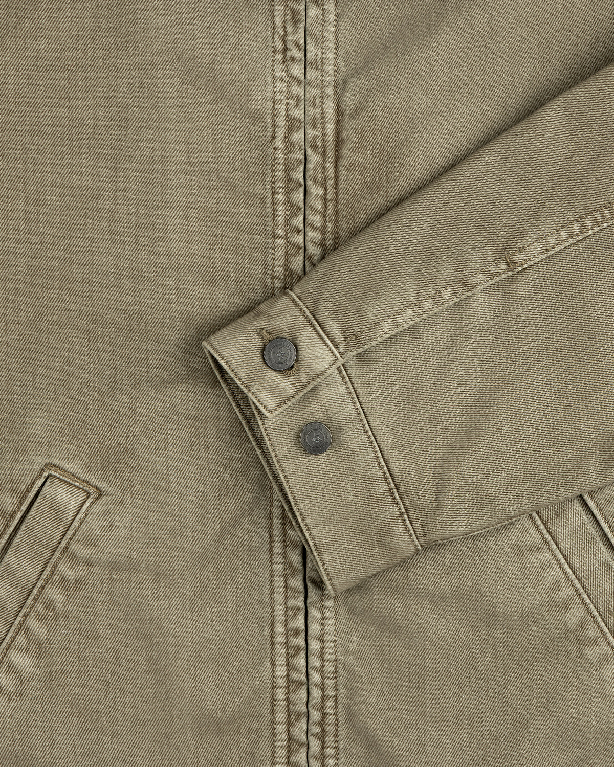 Olive green sleeve of a Flocked Denim Jacket featuring a buttoned cuff.