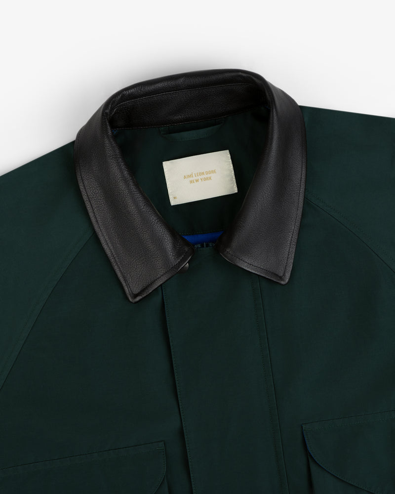 Dark green Lightweight Barn Jacket with black leather collar, partially open to show cream AIME LEON DORE NY label.