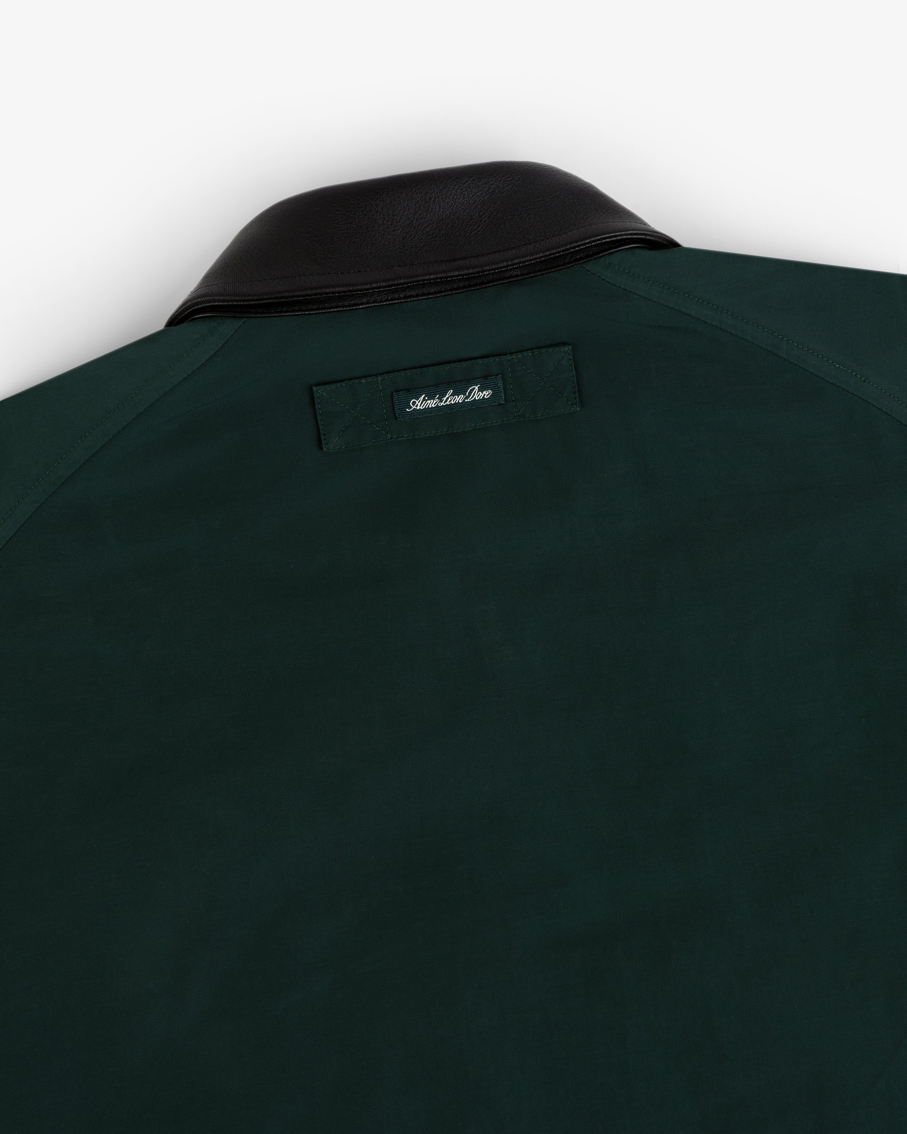 Lightweight Barn Jacket in dark green with black leather collar, rear view showing a small label below the collar.
