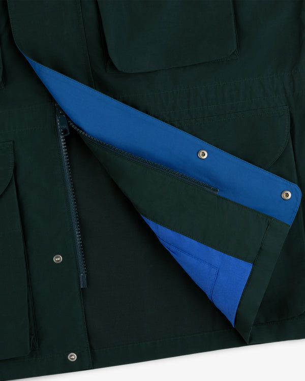 Close-up of the Lightweight Barn Jacket in dark green with blue lining, featuring zipper, snap buttons, and pockets.