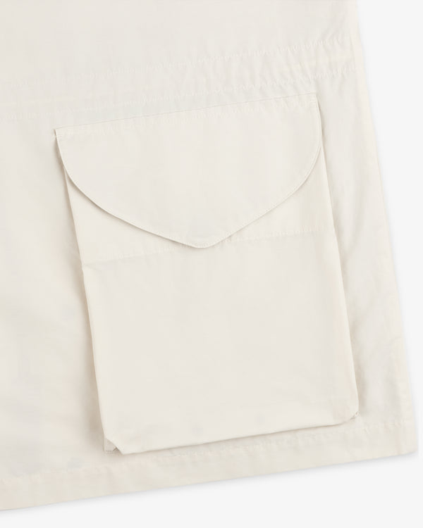 Close-up of a beige Lightweight Barn Jacket with a flap pocket on the front.