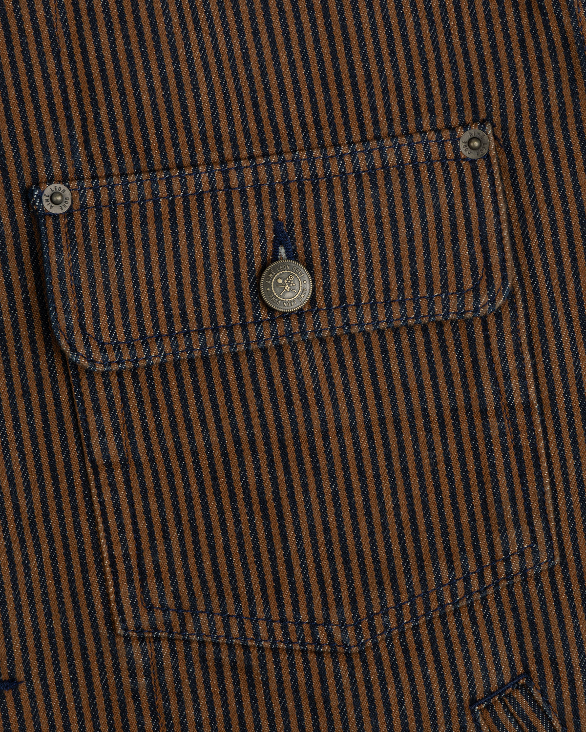 Hickory Stripe Denim Trucker Jacket with brown and navy stripes, pocket, and metal buttons on the garment.