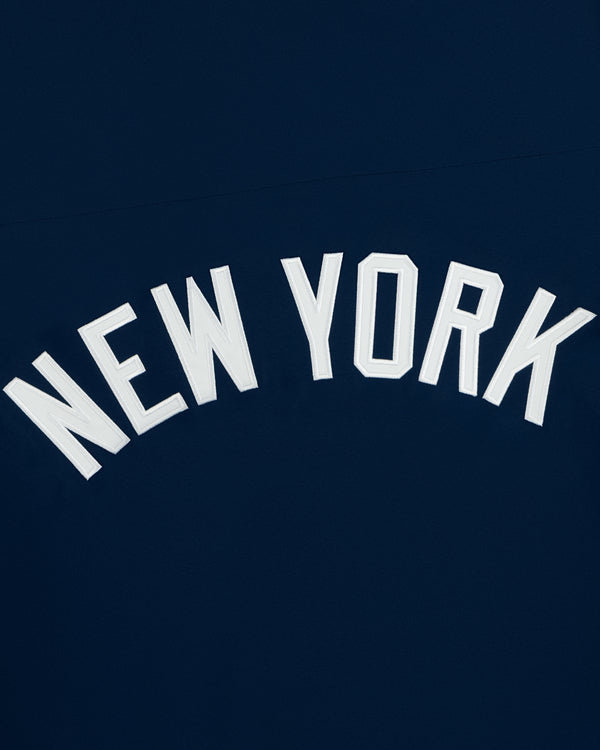 Yankees GORE-TEX Rain Delay Jacket with white “NEW YORK” in an upward arch on a dark blue background.