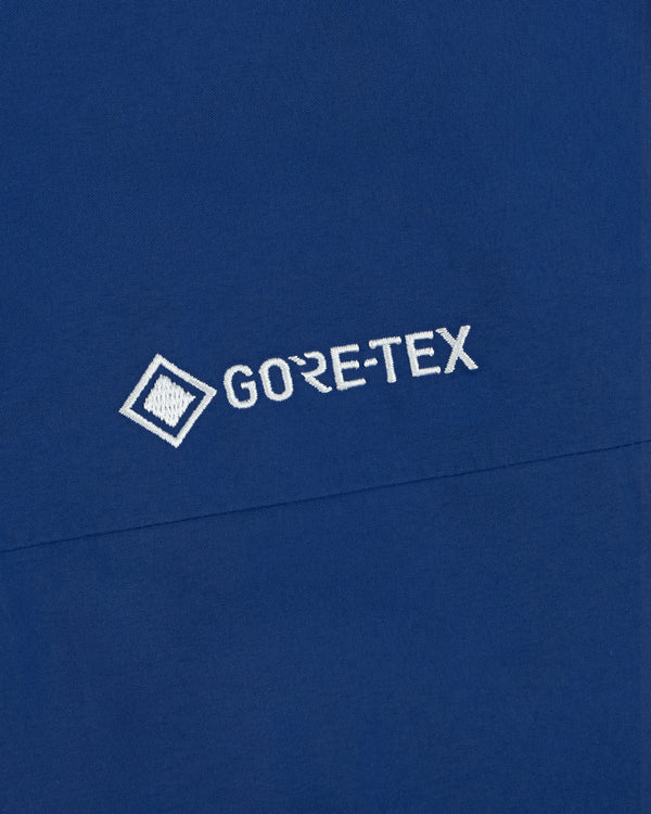 Close-up of the Dodgers GORE-TEX Rain Delay Jacket with a white GORE-TEX logo embroidered on blue fabric.