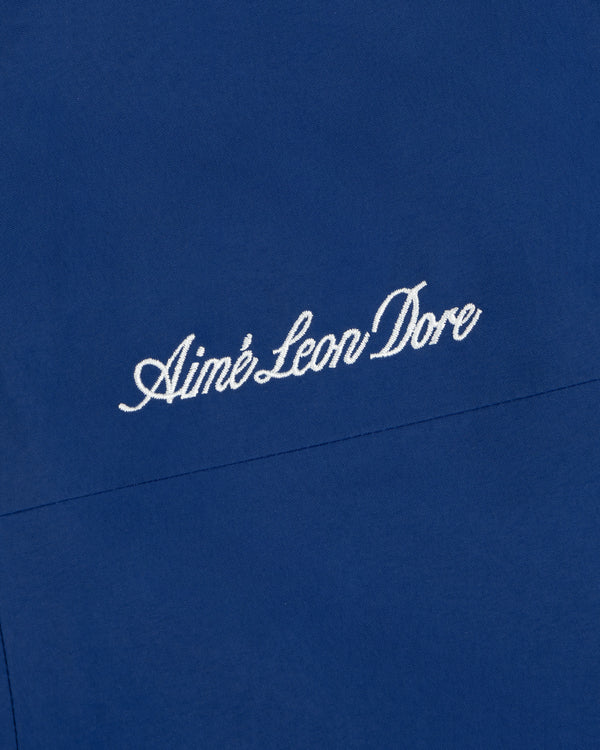 White embroidered logo on blue Dodgers GORE-TEX Rain Delay Jacket fabric background.