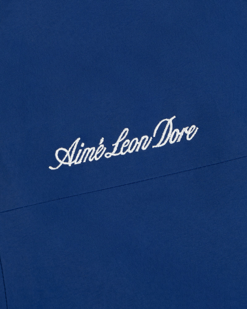 White embroidered logo on blue Dodgers GORE-TEX Rain Delay Jacket fabric background.