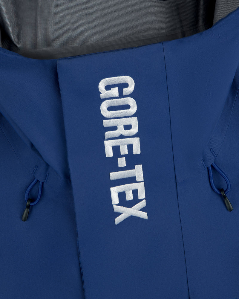 Close-up of Dodgers GORE-TEX Rain Delay Jacket showing white GORE-TEX text on front flap and black drawstrings.