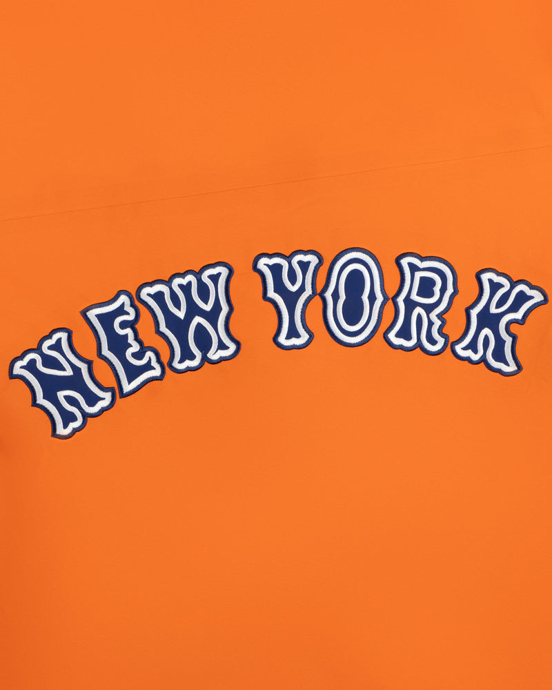 The words NEW YORK in wavy blue and white letters on Mets GORE-TEX Rain Delay Jacket’s bright orange background.