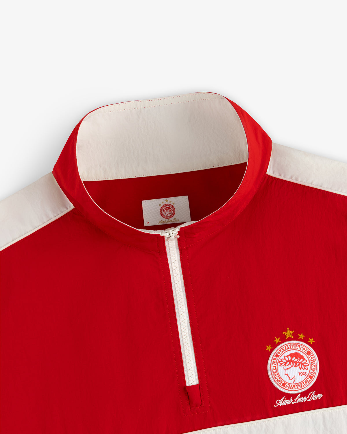 Red and white ALD / Olympiacos F.C. Nylon Quarter Zip Pullover with a team crest and text on the chest.