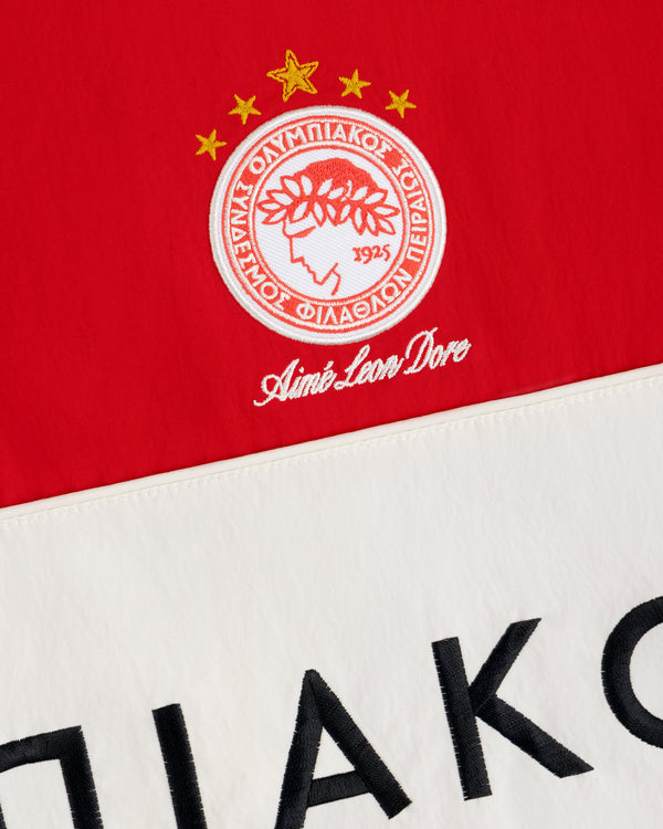 Red and off-white ALD / Olympiacos F.C. Nylon Quarter Zip Pullover featuring an embroidered crest with stars and text.