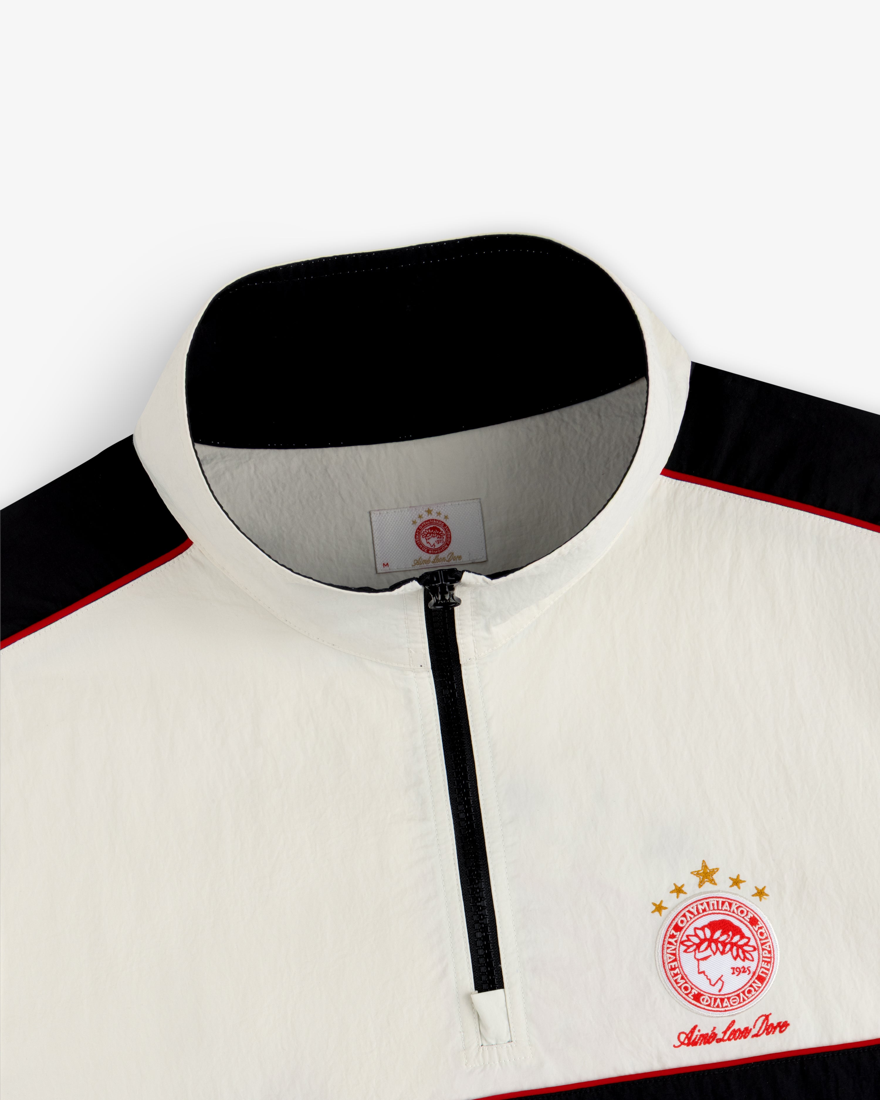 Off-white ALD / Olympiacos F.C. Nylon Quarter Zip Pullover with black accents and a red and gold sports emblem.