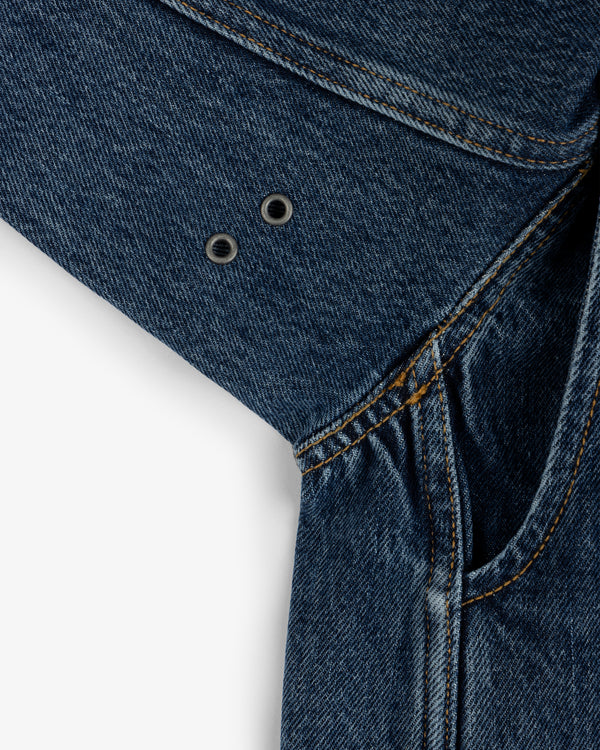 Close-up of the Denim Chore Coat underarm featuring two metal ventilation grommets on blue denim.