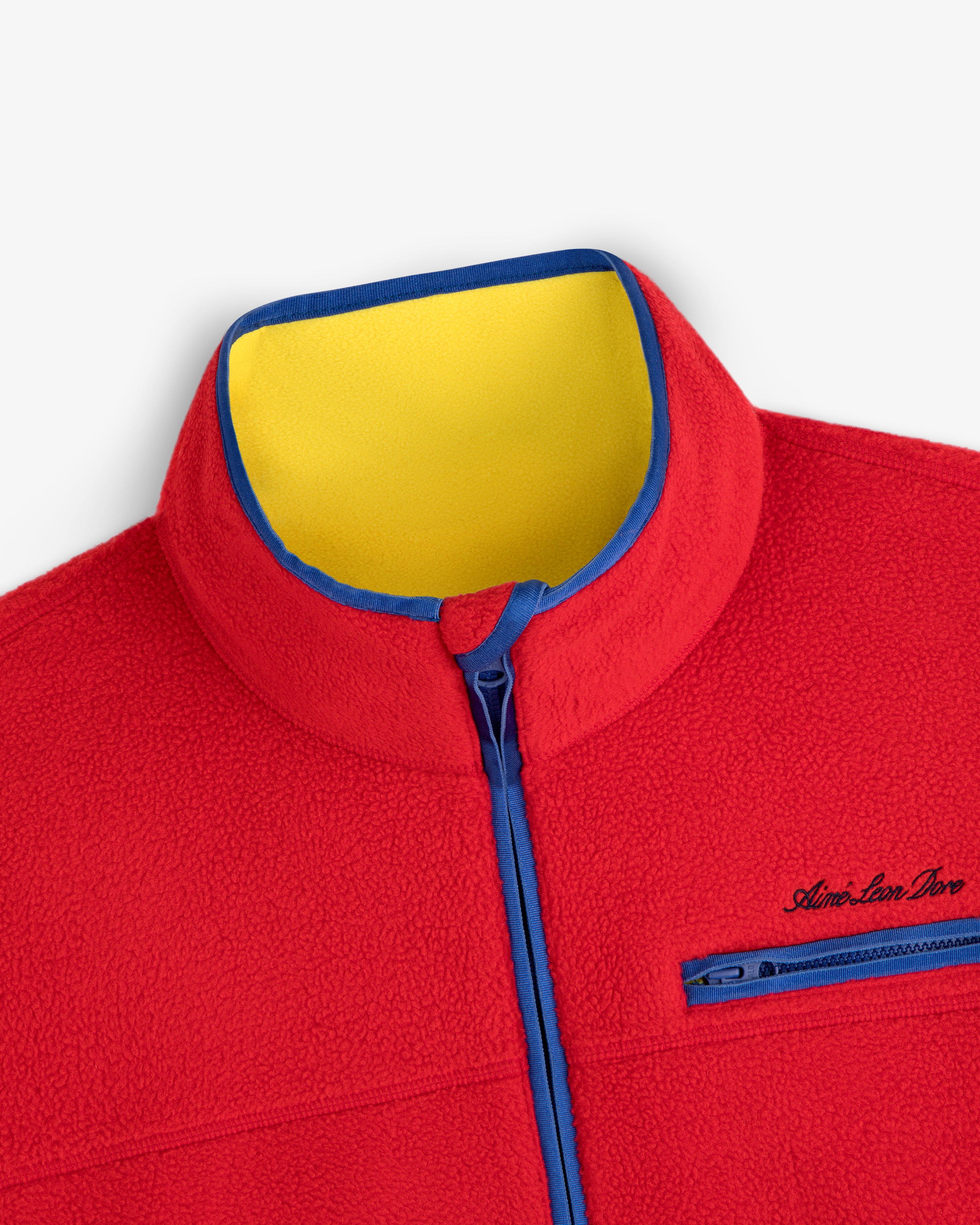 Script Fleece Half Zip Pullover in red with a yellow inner collar, blue trim, and a zippered chest pocket.