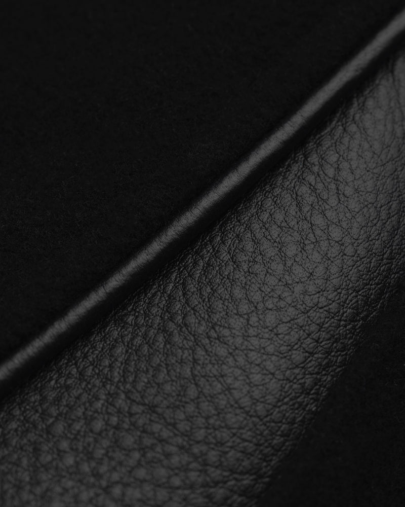 Close-up of the ALD / Olympiacos F.C. Team Leather Jacket in black leather and suede panels separated by a piped seam.