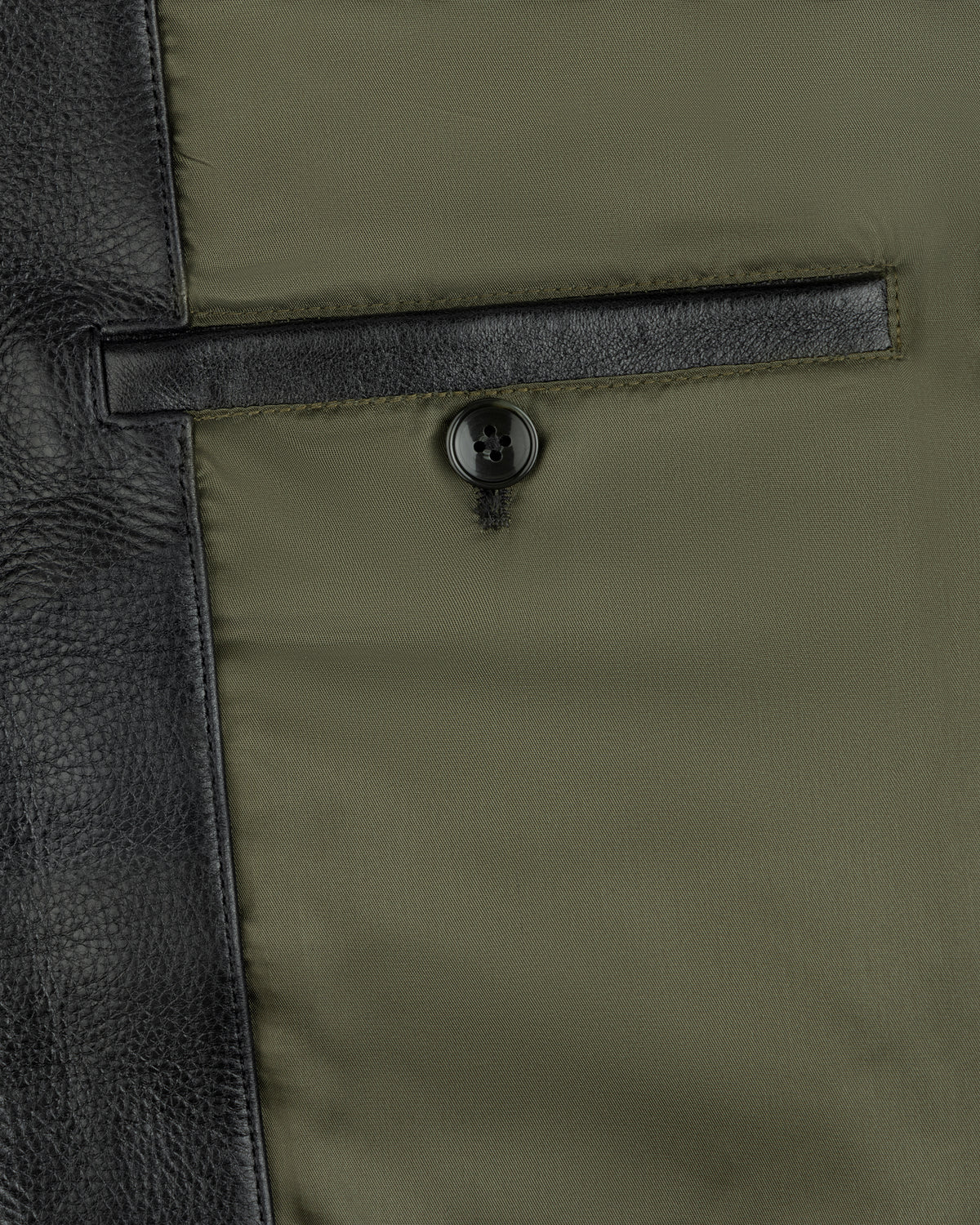 Interior view of a Napa Leather Bomber Jacket featuring a green lining, a leather-trimmed pocket, and a button closure.